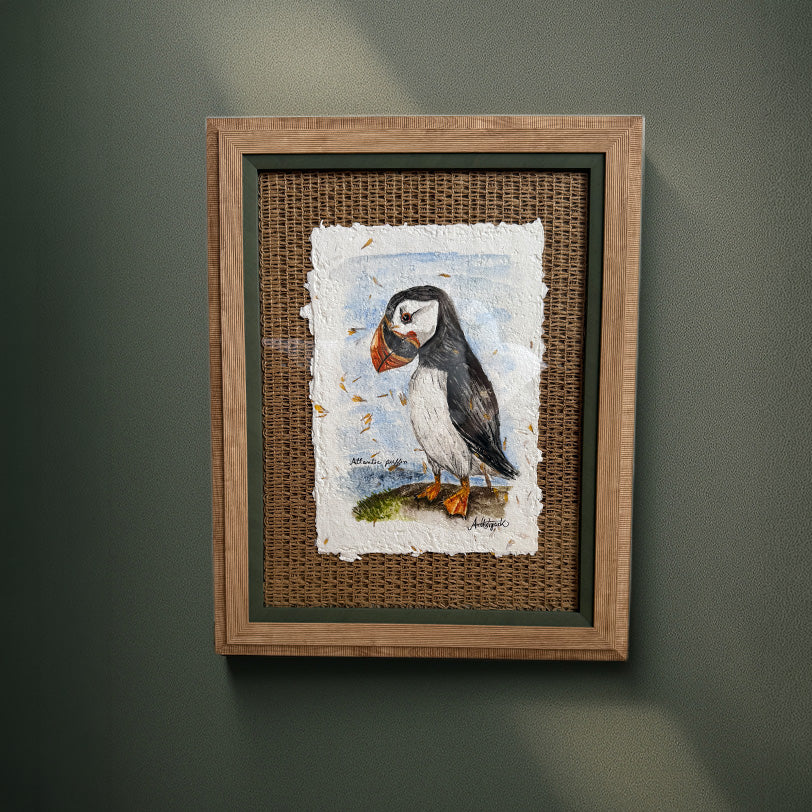 Framed artwork of a puffin on a textured wall