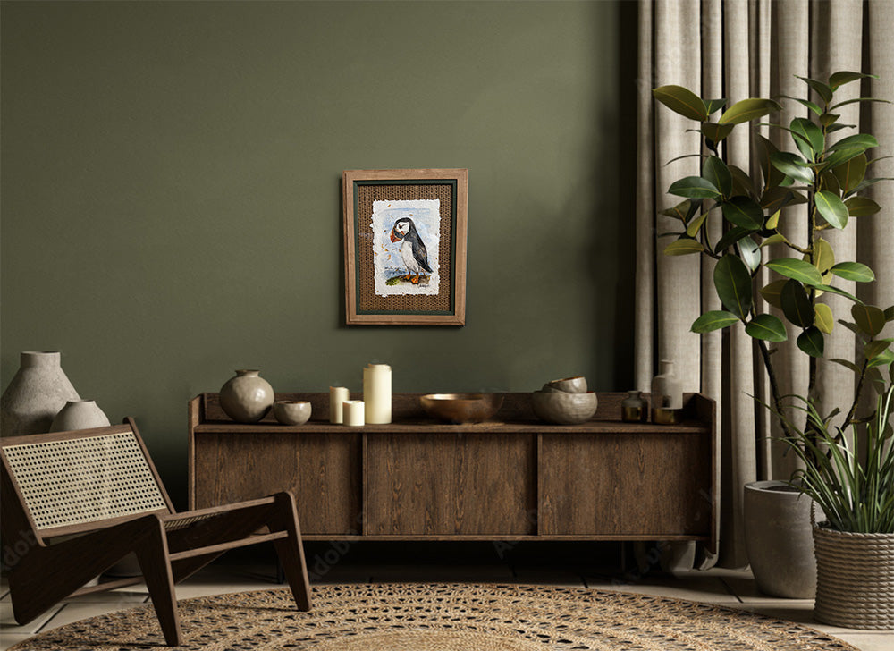 Living room with wooden sideboard, chair, and framed picture on a green wall.